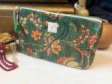 Load image into Gallery viewer, A quilted fabric zip pouch with a vintage floral tapestry pattern in green, orange, and red, featuring a small white brand label and a green tassel zipper pull.